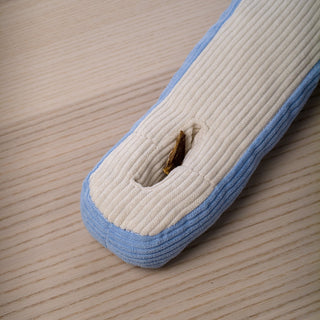 A dried jerky dog treat tucked into the slot of an Udon snuffle toy.