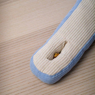 A dog treat tucked into the slot of an Udon snuffle toy.