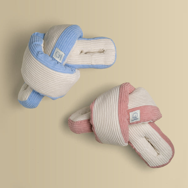 A blue and pink Udon snuffle plush toy tied into a knot against a yellow background.